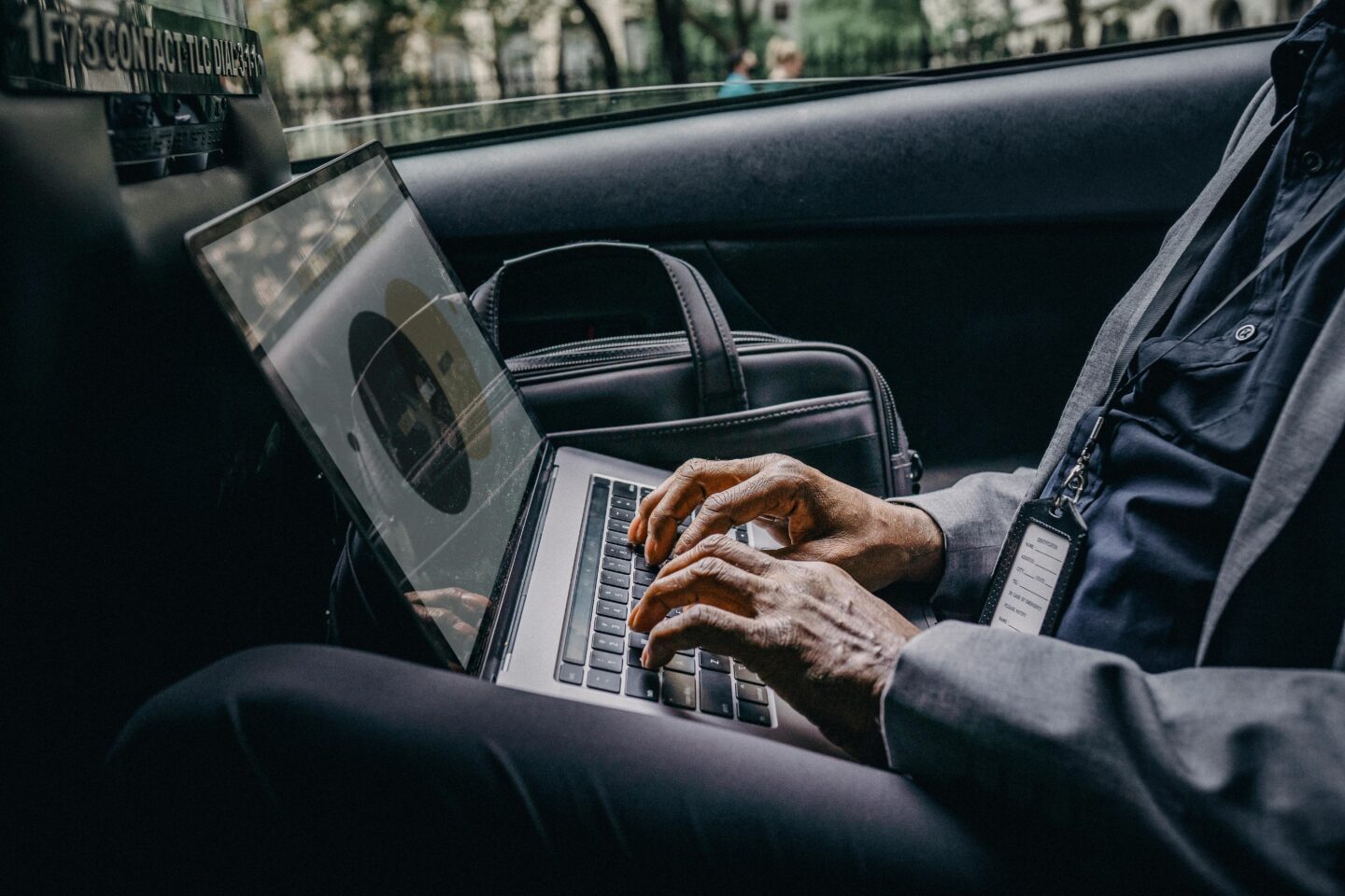 persona che lavora al pc all’interno di un’auto
